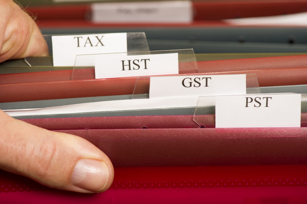 File folders that are labelled GST, HST, PST and Tax