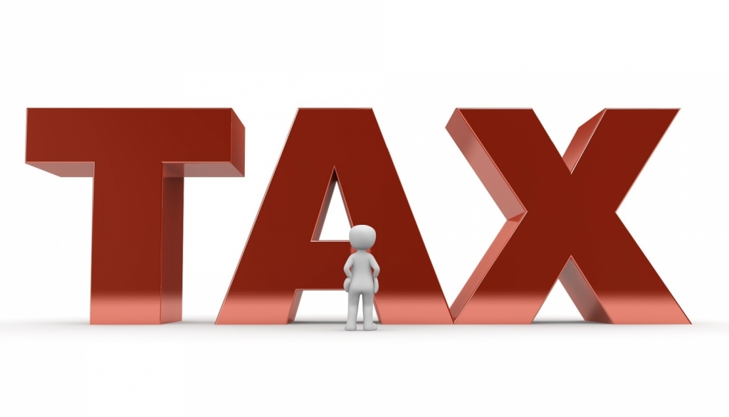 The word tax (large) with a little computer generated person looking up at it