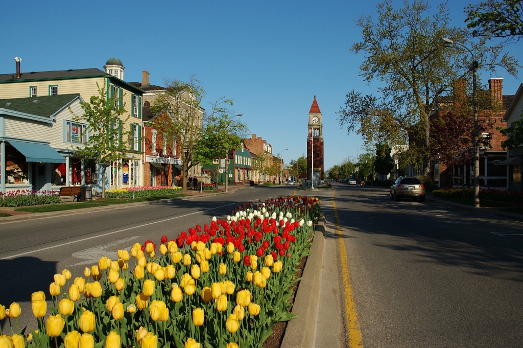 A view looking west along Queen Street, Niagara on the Lake, Ontario, Canada showing the profusion of spring flowers, with the Clock Tower.
