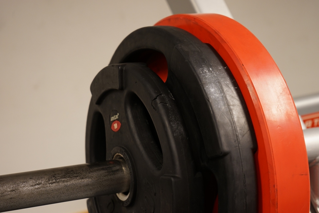 Close up of a bar bell with red and black weights