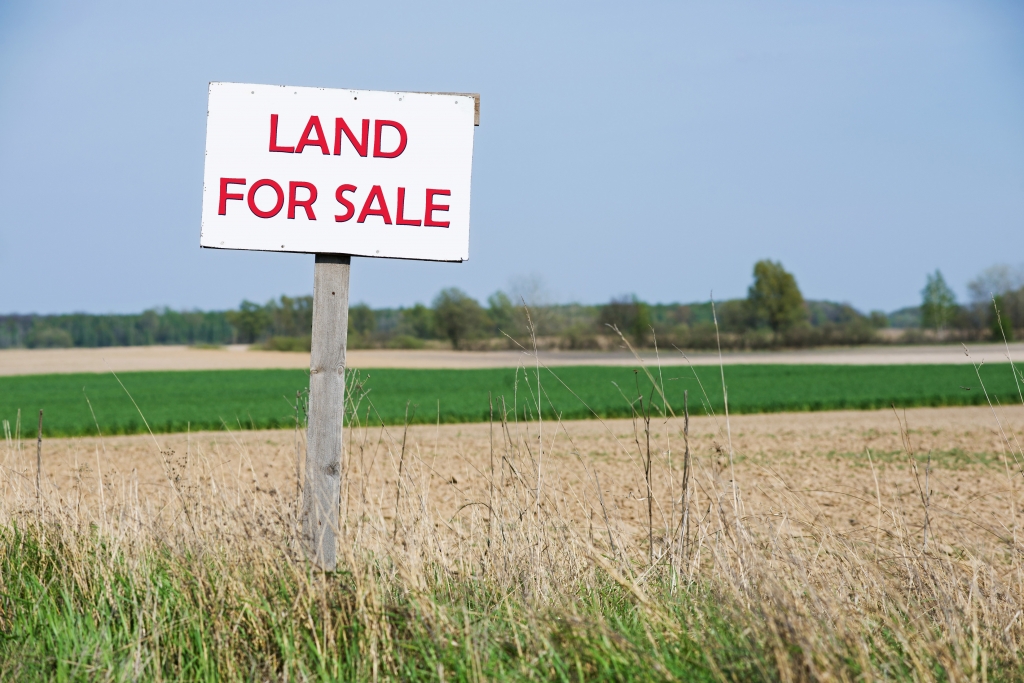 farmland with a red for sale sign in front