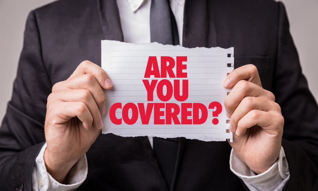 close up of sign that reads "Are You Covered", held by business man
