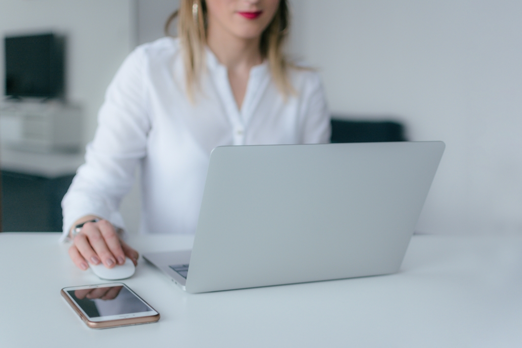 woman on laptop with iphone beside her