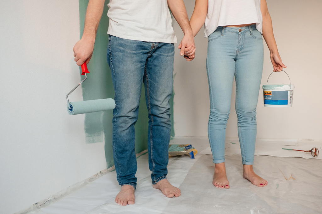 man & woman holding hands with paint brushes