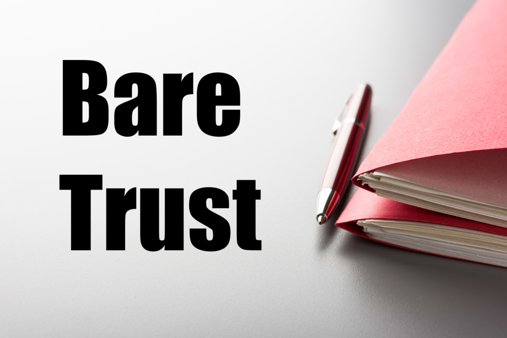 The words Bare Trust written beside a pen & file folders