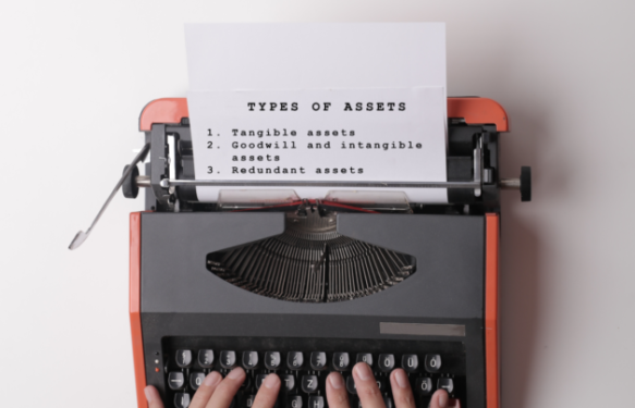 Red typewriter with paper listing the three types of assets