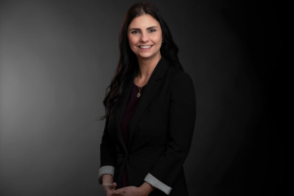 Professional photo of Ashley Angelone standing in front of a black gradient background