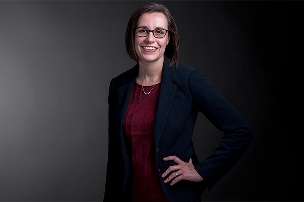 Professional photo of Alisha Kowalski standing in front of a black gradient background.
