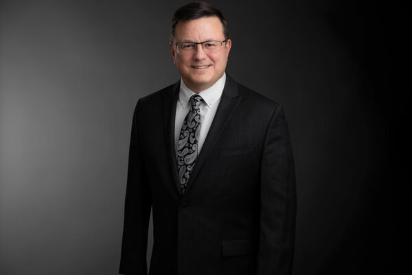 Professional photo of Brad Giroux standing in front of a black gradient background