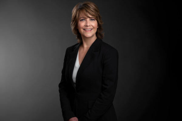 Professional photo of Cathy Guerra standing in front a black gradient background