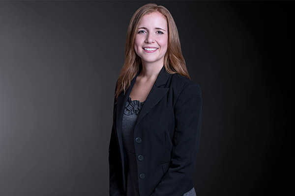 Professional photo of Erin Dubecki standing in front of a black gradient background
