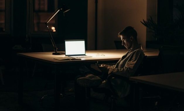 Man sitting in front of a computer late at night working
