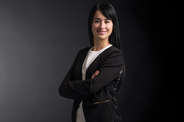 Professional photo of Mariana Camacho standing in front of a gradient background.