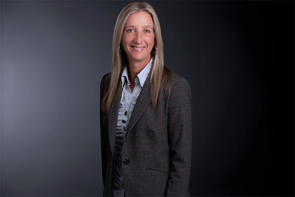 Professional photo of Marleen McMaster standing in front of a black gradient background.