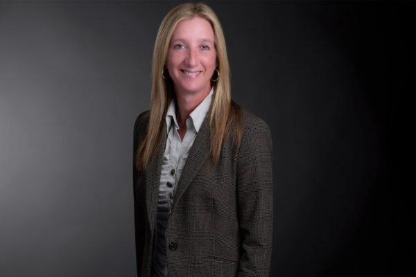 Professional photo of Marleen McMaster standing in front of a black gradient background.