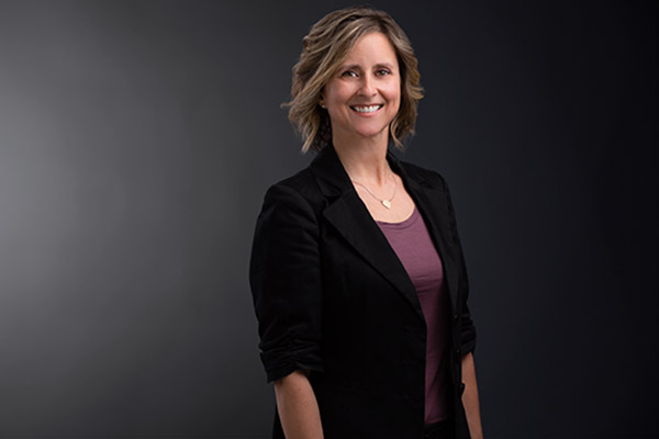 Professional Photo of Michelle DeLuca standing in front of a black gradient background