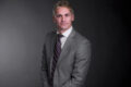 Professional photo of Mike Pychel standing in front of a black gradient background