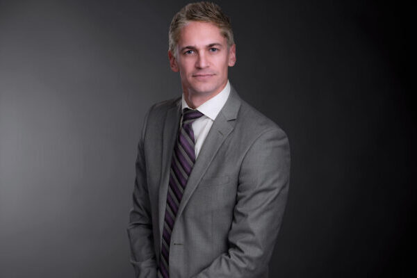 Professional photo of Mike Pychel standing in front of a black gradient background