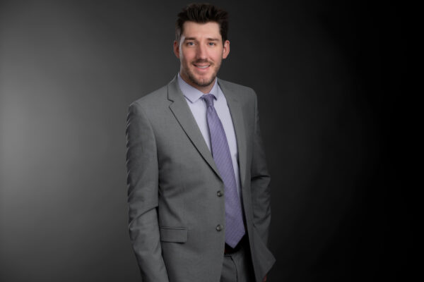 Professional photo of Tyler Parkin standing in front of a black gradient background