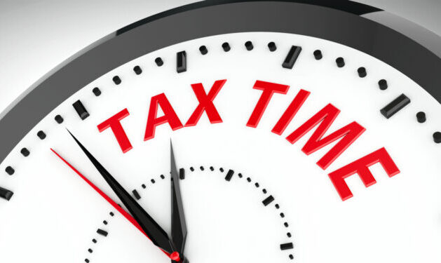 Close-up of clock with the words Tax Time written in red