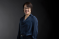 Professional photo of Angela Liang standing in front of a black gradient background.