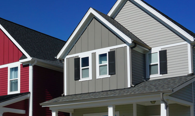 Close up of second story of a grey house with a red house on the left