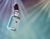 Isolated microphone on teal and purple background with spotlights