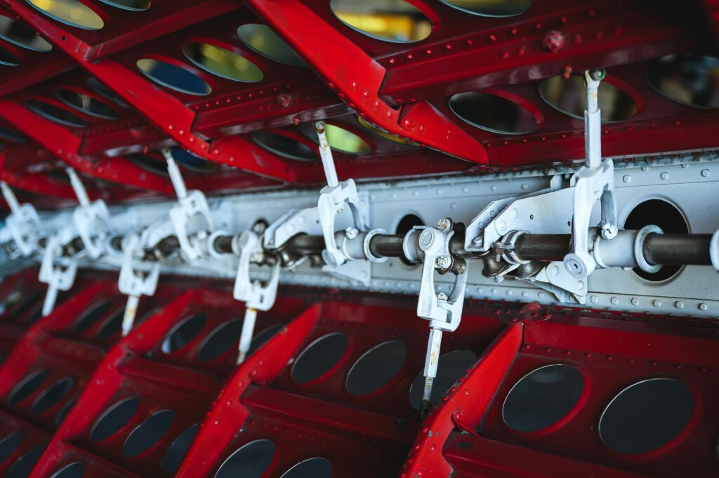 Close up of red & silver manufacturing machine.