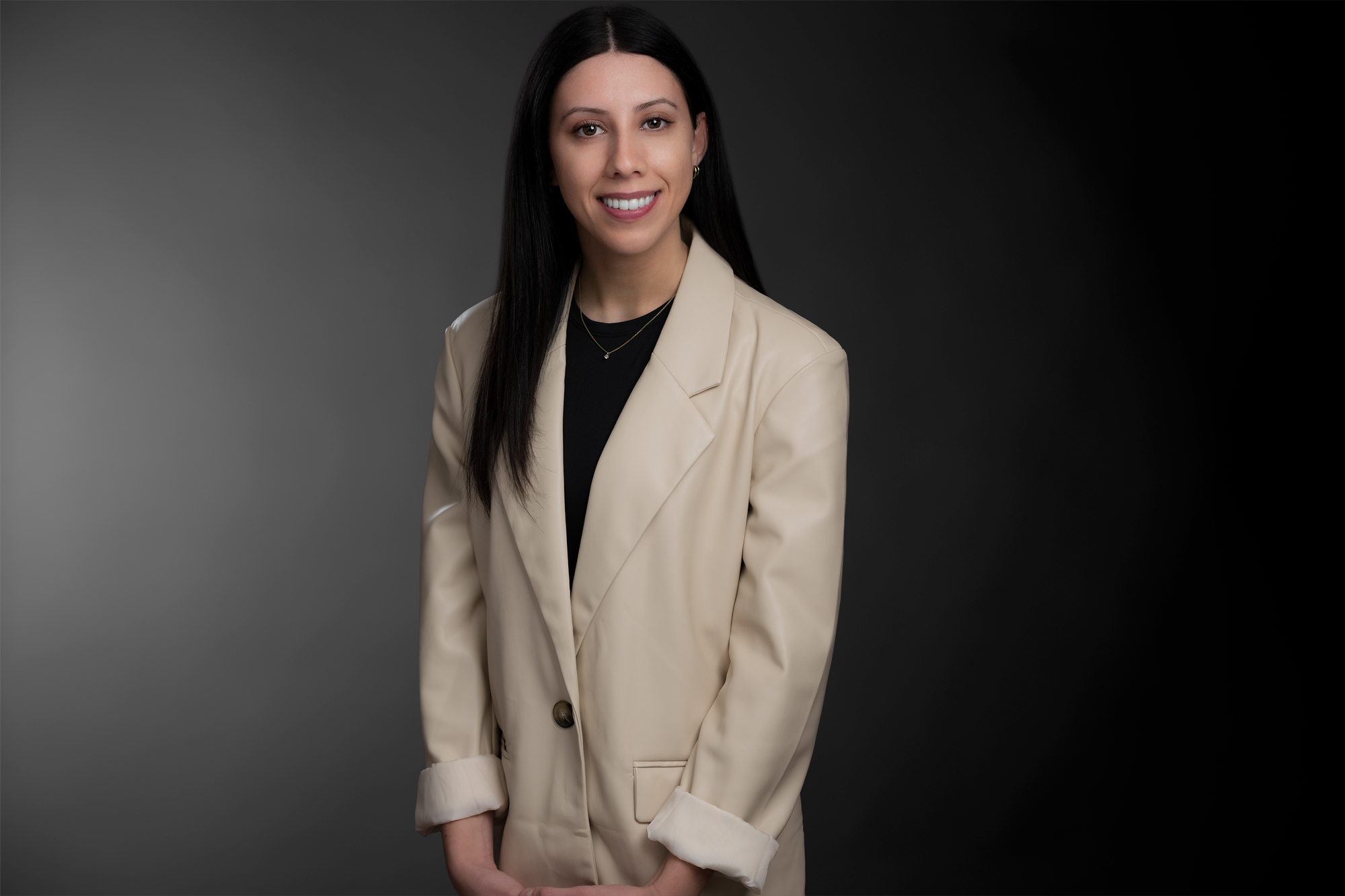 Professional photo of Emily Petro standing in front of a black gradient background.