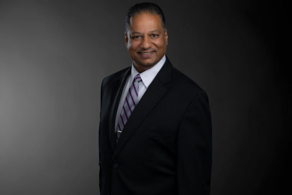 Professional photo of Tony Brigmohan standing in front of a black gradient background