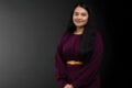 Professional photo of Simran Kaur standing in front of a black gradient background