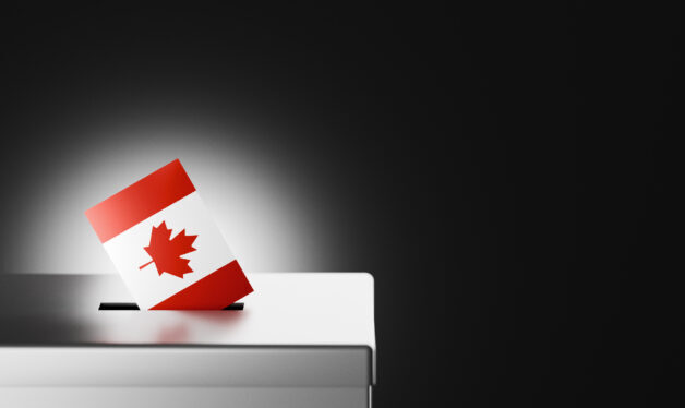 The Canadian flag, with its iconic red maple leaf on a white background, is shown being placed into a ballot box, symbolizing the democratic process and voter participation in Canada. This image captures themes of national identity, political responsibility, and civic duty, making it ideal for illustrating Canadian elections, government processes, and the importance of voting rights. Perfect for use in news articles, educational content, and social media posts related to Canadian democracy, elections, and civic engagement.