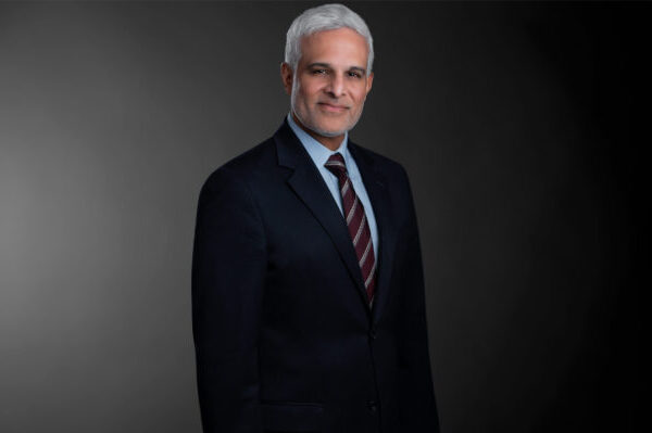 Professional photo of Ben Alexander standing in front of a black gradient background.