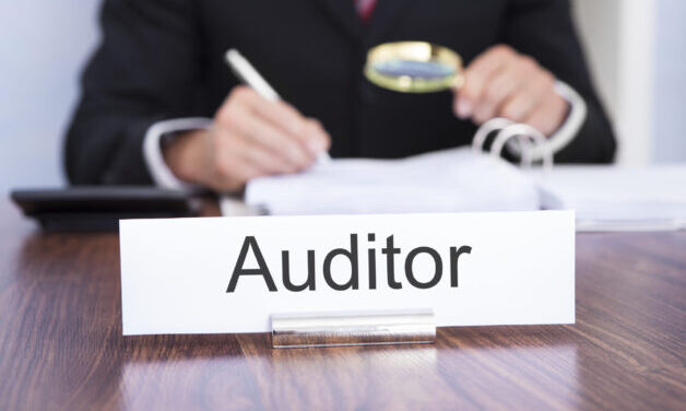 Businessman Looking At Document Through Magnifying Glass