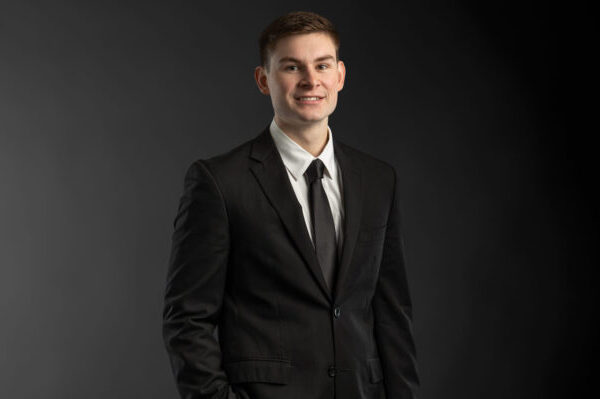 Professional photo of Michael Lloyd standing in front of a black gradient background.
