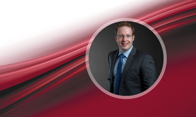 Professional photo of Travis Redding. Background red/black/white swirls.