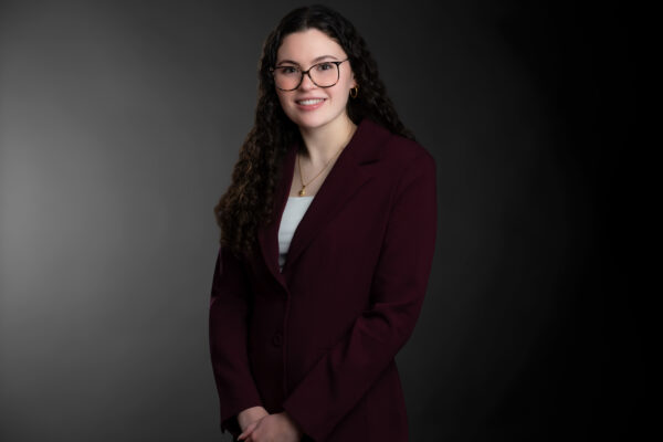 Professional photo of Sierra Varga standing in front of a black gradient background.