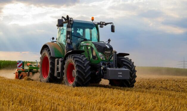 Green tractor plowing fields.